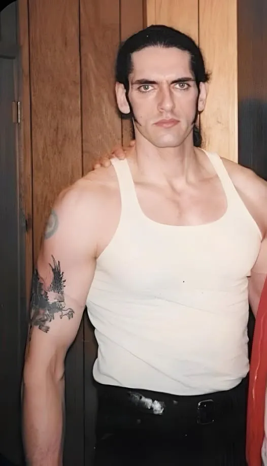 Young Peter Steele backstage in white tank top showing his tattoos